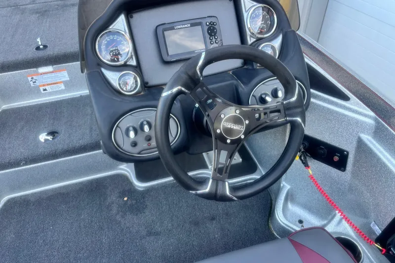 Slide: The Image of 2024 Triton 18 TrX boat dashboard with steering wheel and control panel. - 10