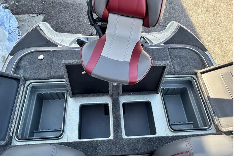 Slide: The Image of 2024 Triton 18 TrX boat interior with storage compartments and a red-gray seat. - 12