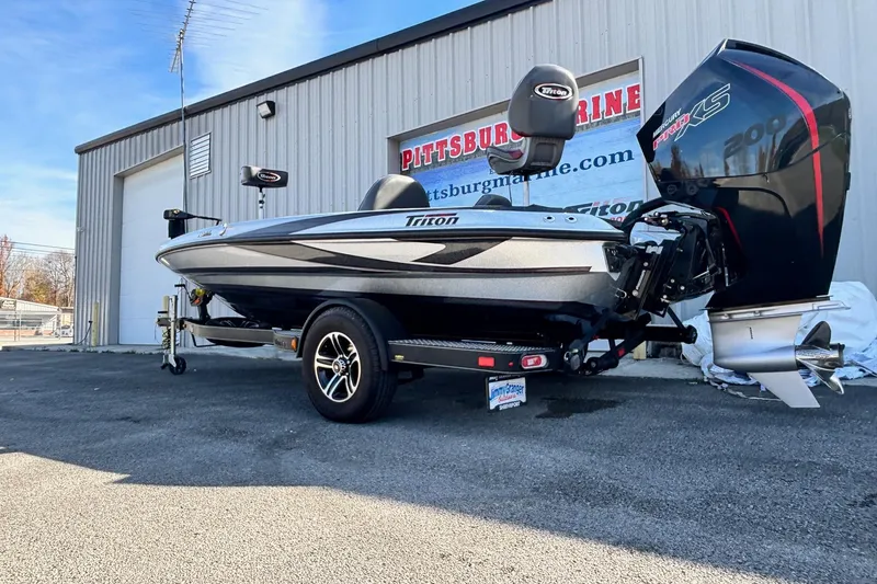 Slide: The Image of 2024 Triton 18 TrX boat with powerful engine, parked outside Pittsburg Marine. - 14