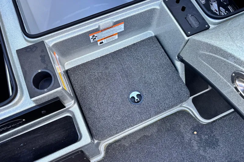 Slide: The Image of Interior of 2024 Triton 18 TrX boat showing storage compartment and cup holder. - 6