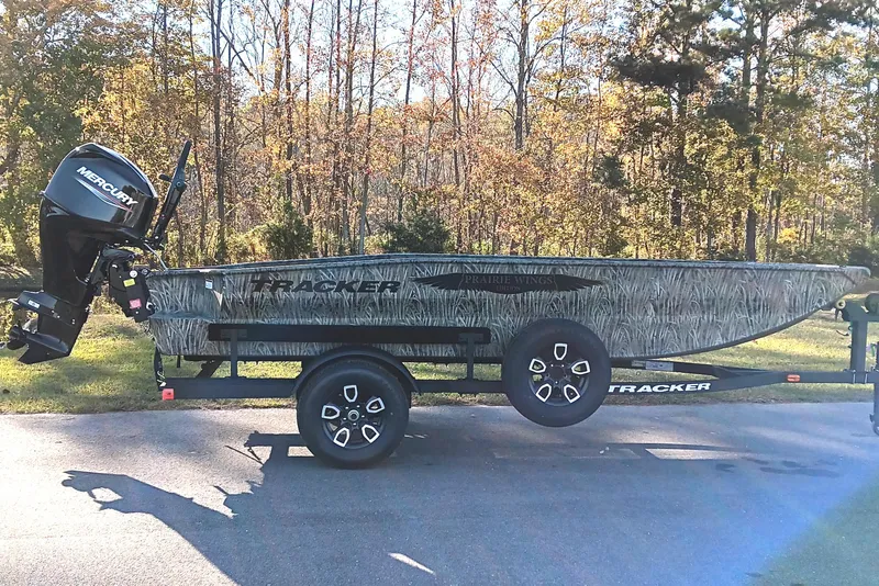 The Image of 2026 Tracker Grizzly 1650 T Prairie Wings Edition boat on trailer, outdoors. - 1