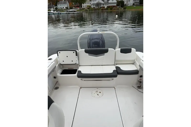 Slide: The Image of 2025 Robalo R207 Dual Console boat interior with seating and storage, docked by waterfront homes. - 10