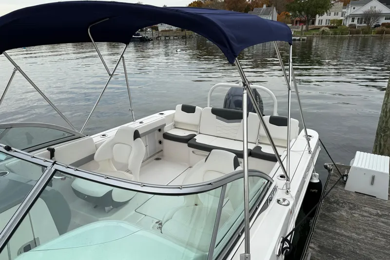 Slide: The Image of 2025 Robalo R207 Dual Console boat docked by a serene waterfront. - 3