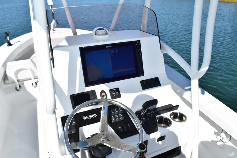 Slide: The Image of 2020 BlackJack 256 Coastal boat dashboard with steering wheel and navigation display. - 16