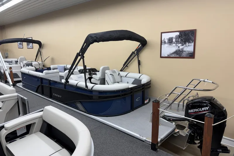 Slide: The Image of 2025 Crest Classic 240 pontoon boat with Mercury engine in showroom display. - 11