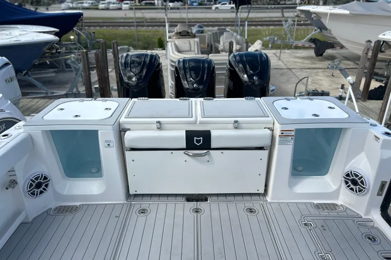 Slide: The Image of 2026 Sea Fox 368 Commander boat deck with triple outboard engines and storage compartments. - 56