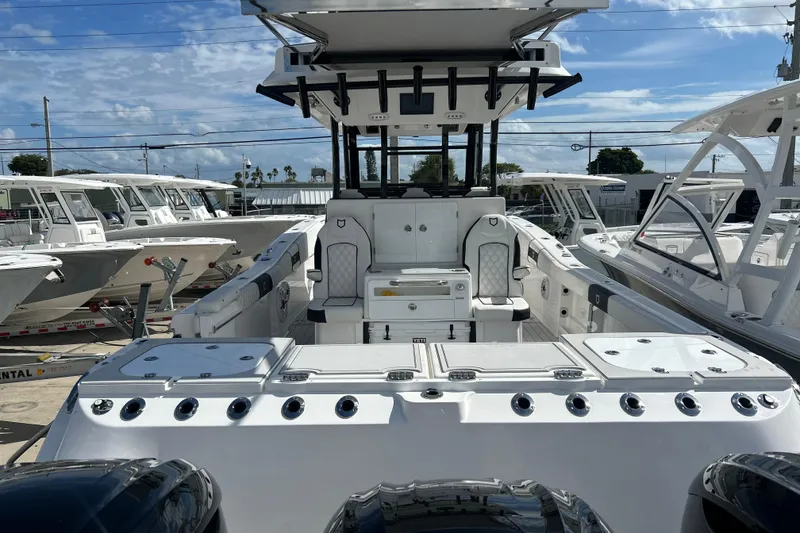 Slide: The Image of 2026 Sea Fox 368 Commander boat interior with seating and storage, docked under a clear sky. - 76