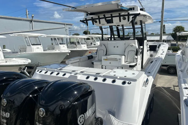 Slide: The Image of 2026 Sea Fox 368 Commander boat with Yamaha engines, docked under a clear blue sky. - 77