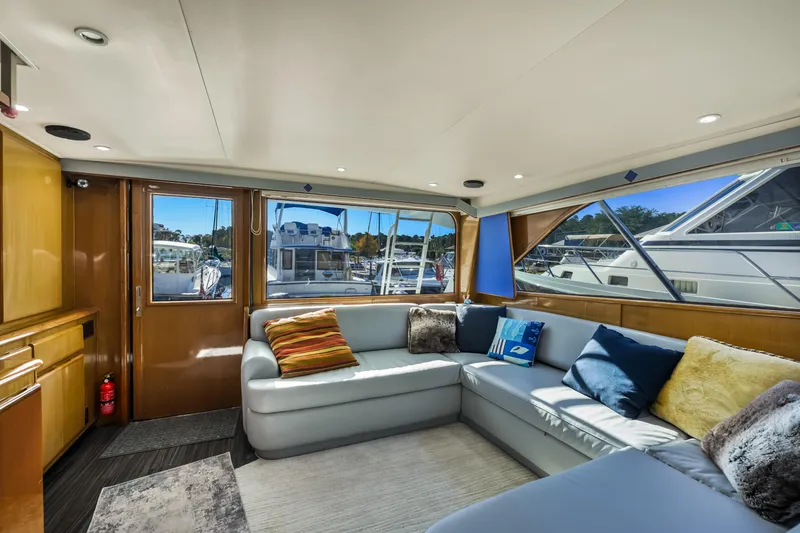 Slide: The Image of Luxurious interior of a 1999 Viking 58 Convertible yacht with plush seating and marina view. - 12