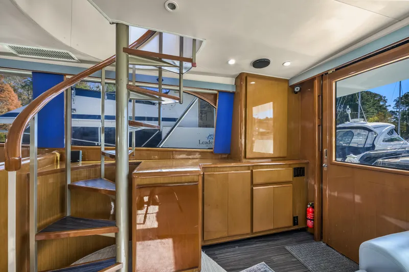 Slide: The Image of Interior of 1999 Viking 58 Convertible yacht with spiral staircase and wooden cabinetry. - 14