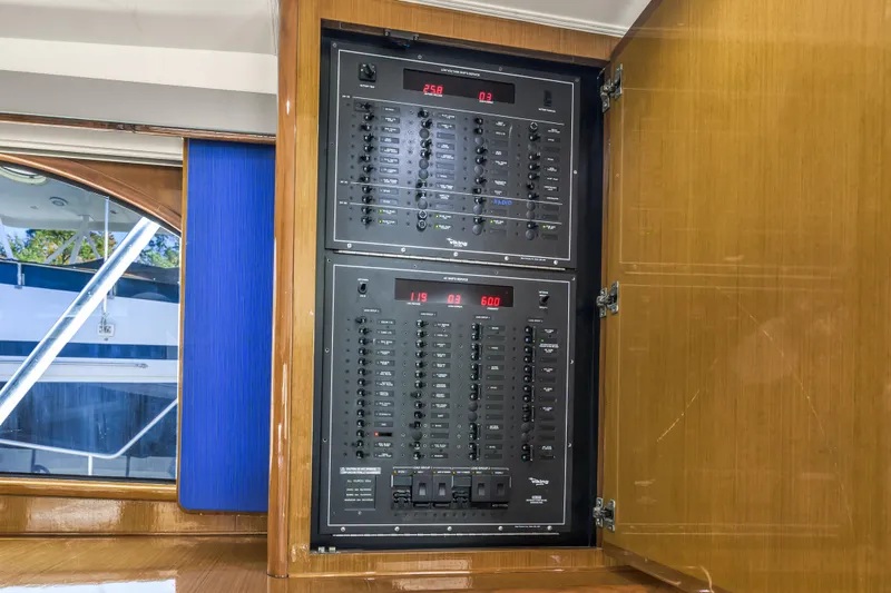 Slide: The Image of Electrical panel inside 1999 Viking 58 Convertible yacht, showcasing circuit breakers and controls. - 15