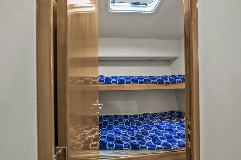 Slide: The Image of Bunk beds with blue bedding in 1999 Viking 58 Convertible yacht cabin. - 21