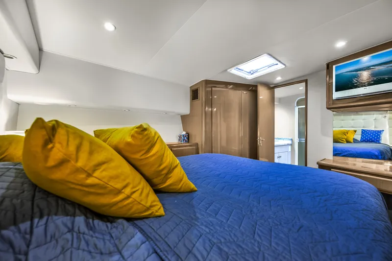 Slide: The Image of Luxurious bedroom interior of 1999 Viking 58 Convertible yacht with blue bedding and yellow pillows. - 26