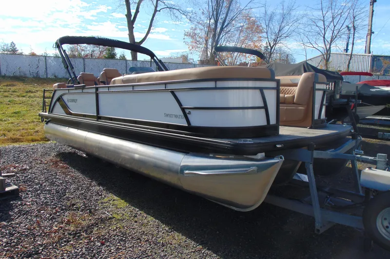 Slide: The Image of 2026 Godfrey Sweetwater 2486 QS iMPACT pontoon boat on trailer, outdoor setting. - 2