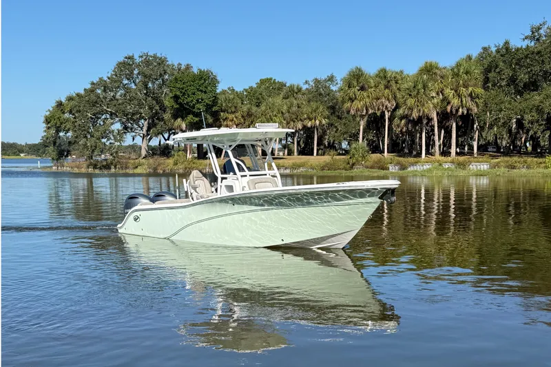 Slide: The Image of 2021 Sea Fox 268 Commander boat cruising on a calm lake with a scenic tree-lined shore. - 10