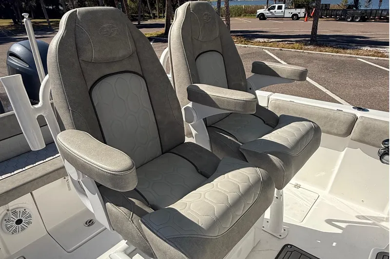 Slide: The Image of 2021 Sea Fox 268 Commander boat seats with armrests in a parking lot setting. - 17