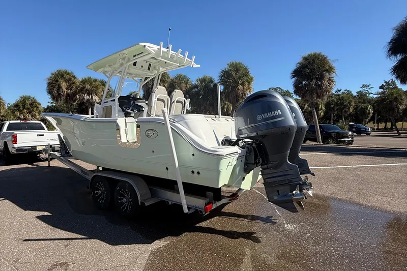 Slide: The Image of 2021 Sea Fox 268 Commander boat on trailer with Yamaha engines, parked near palm trees. - 19