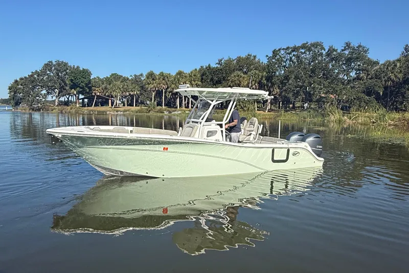 Slide: The Image of 2021 Sea Fox 268 Commander boat on calm water, surrounded by trees. - 2