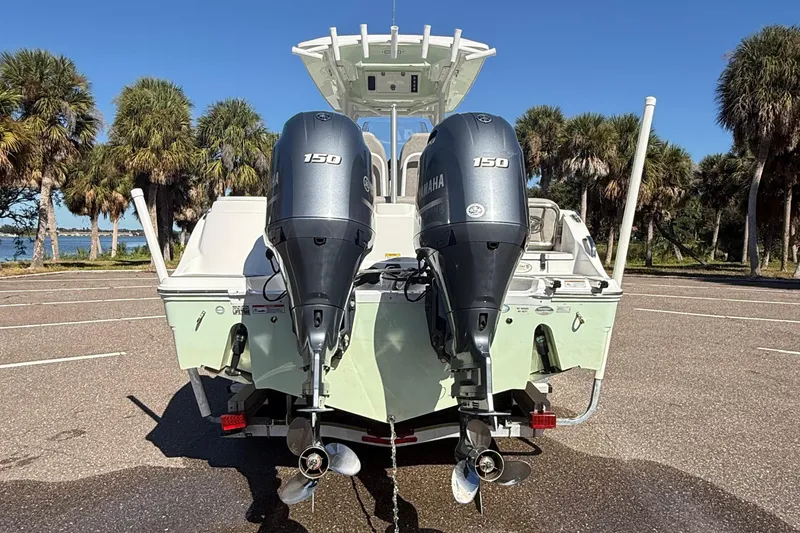 Slide: The Image of 2021 Sea Fox 268 Commander boat with dual Yamaha 150 engines, parked near palm trees. - 20