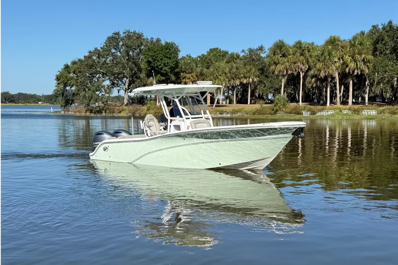 Slide: The Image of 2021 Sea Fox 268 Commander boat on calm water with trees in the background. - 6