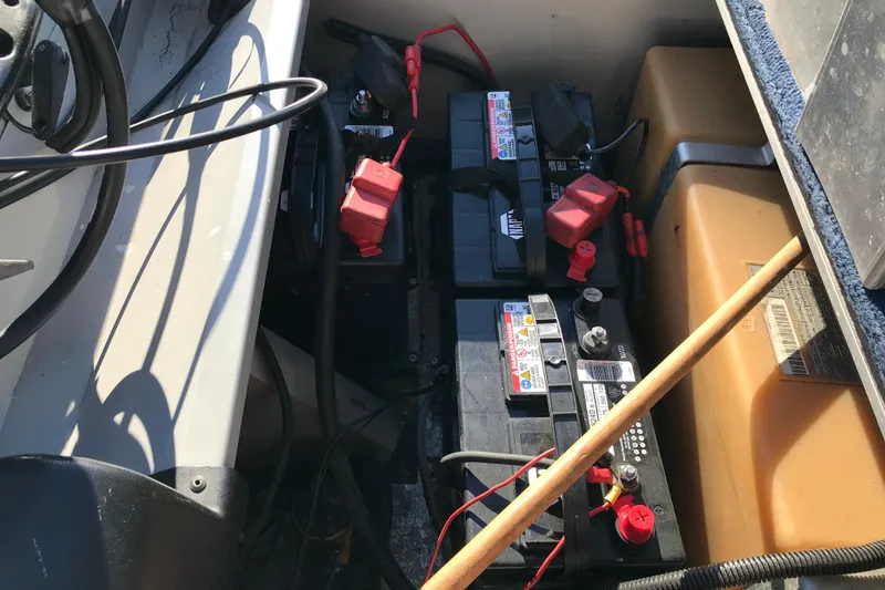 Slide: The Image of 1997 Lowe Bass Striker 170 boat battery compartment with multiple batteries and wiring. - 12