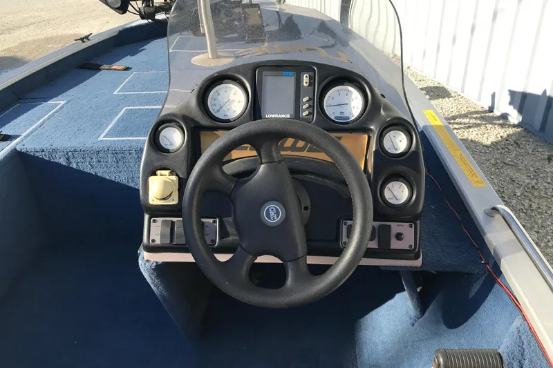 Slide: The Image of 1997 Lowe Bass Striker 170 boat dashboard with steering wheel and gauges. - 13
