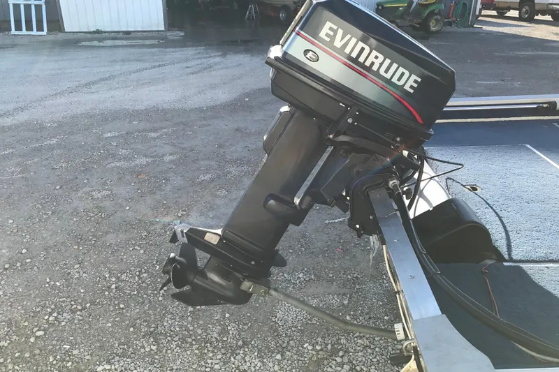 Slide: The Image of 1997 Lowe Bass Striker 170 with Evinrude outboard motor on gravel surface. - 6