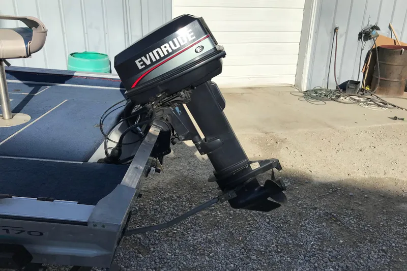 Slide: The Image of 1997 Lowe Bass Striker 170 boat with Evinrude outboard motor in a garage setting. - 7
