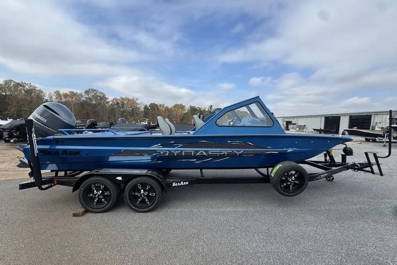 Slide: The Image of 2026 SeaArk Dynasty 2.0 boat on trailer, blue exterior, parked outdoors. - 13