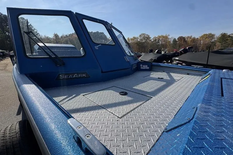 Slide: The Image of 2026 SeaArk Dynasty 2.0 boat with blue exterior and spacious deck in outdoor setting. - 19