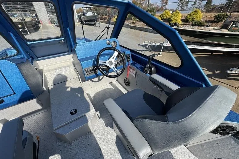 Slide: The Image of Interior of 2026 SeaArk Dynasty 2.0 boat with steering wheel and seating. - 23