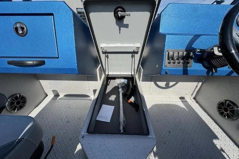 Slide: The Image of Interior of 2026 SeaArk Dynasty 2.0 boat showing storage compartment and control panel. - 26