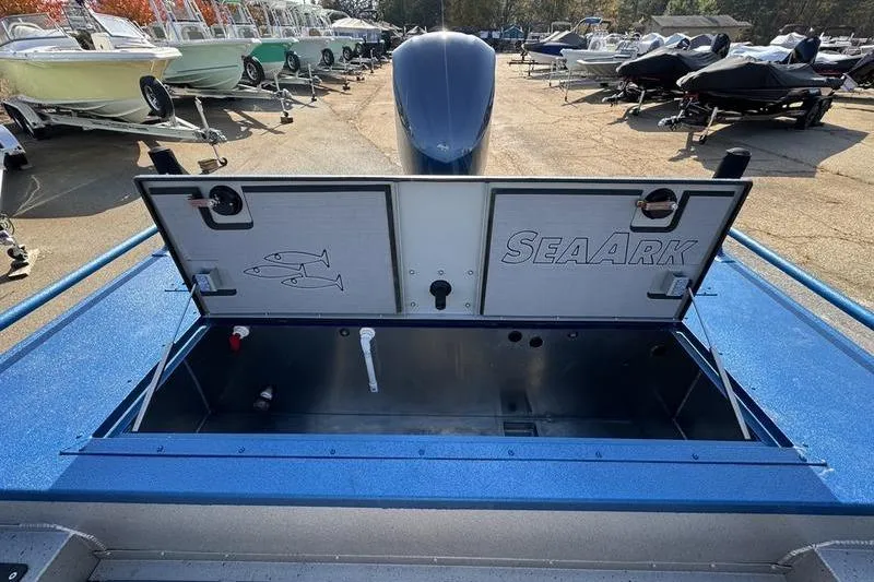 Slide: The Image of 2026 SeaArk Dynasty 2.0 boat with open storage compartment in a boatyard. - 28