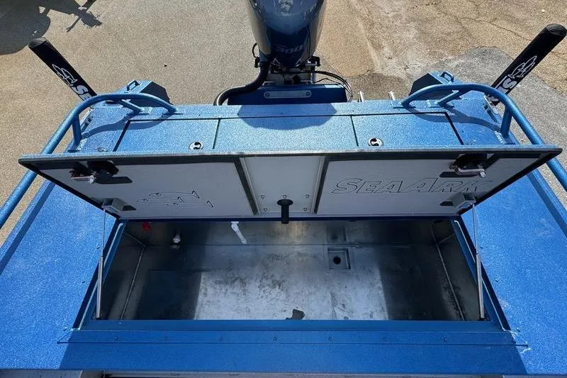 Slide: The Image of 2026 SeaArk Dynasty 2.0 boat with open storage compartment, blue exterior, and visible motor. - 30
