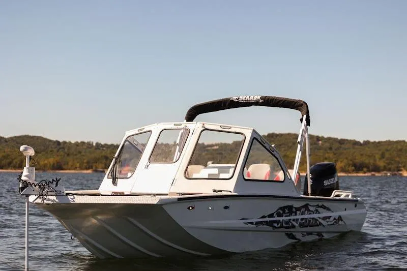 Slide: The Image of 2026 SeaArk Dynasty 2.0 boat on a lake with scenic background. - 34