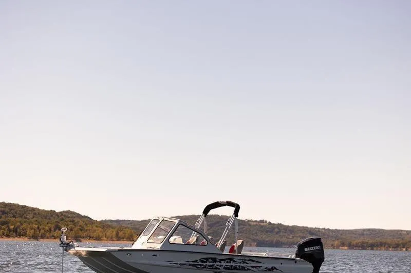 Slide: The Image of 2026 SeaArk Dynasty 2.0 boat on a lake with scenic background. - 35