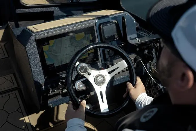 Slide: The Image of Person steering 2026 SeaArk Dynasty 2.0 boat with navigation display. - 39