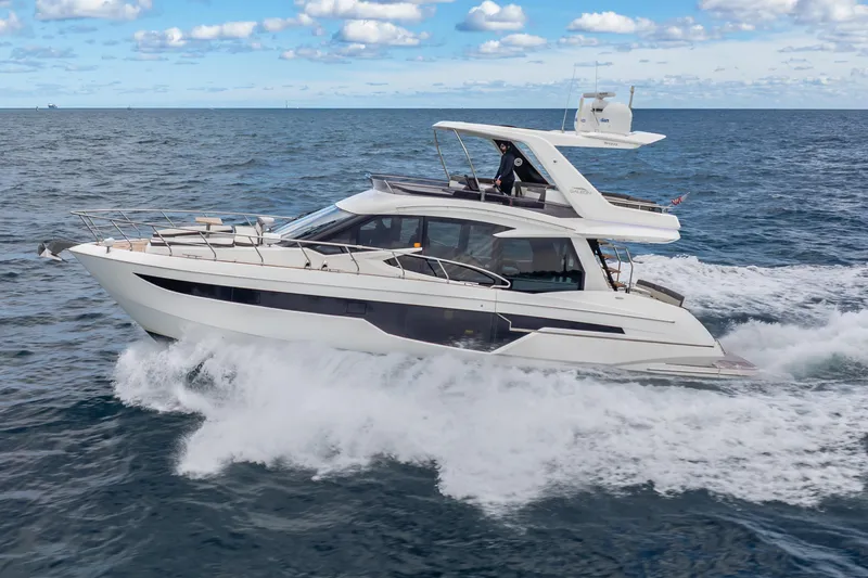Slide: The Image of 2020 Galeon 500 Fly yacht cruising on open sea under a partly cloudy sky. - 1