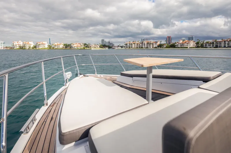 Slide: The Image of 2020 Galeon 500 Fly yacht deck with seating and table, overlooking waterfront buildings. - 15