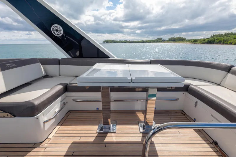 Slide: The Image of Luxurious 2020 Galeon 500 Fly yacht deck with seating and table, overlooking serene waters. - 20