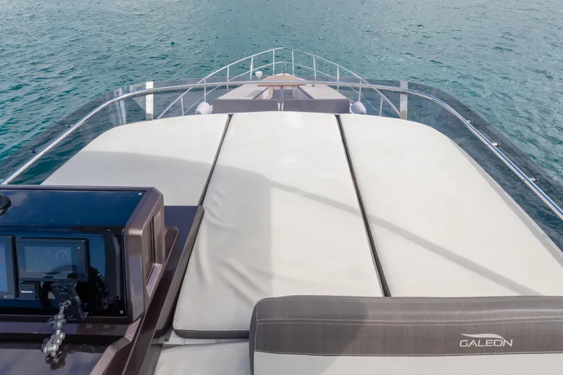 Slide: The Image of 2020 Galeon 500 Fly yacht deck with navigation controls and cushioned seating. - 29