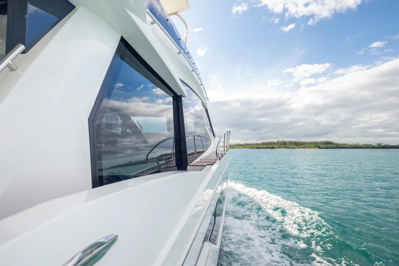 Slide: The Image of 2020 Galeon 500 Fly yacht cruising on clear blue waters under a partly cloudy sky. - 64