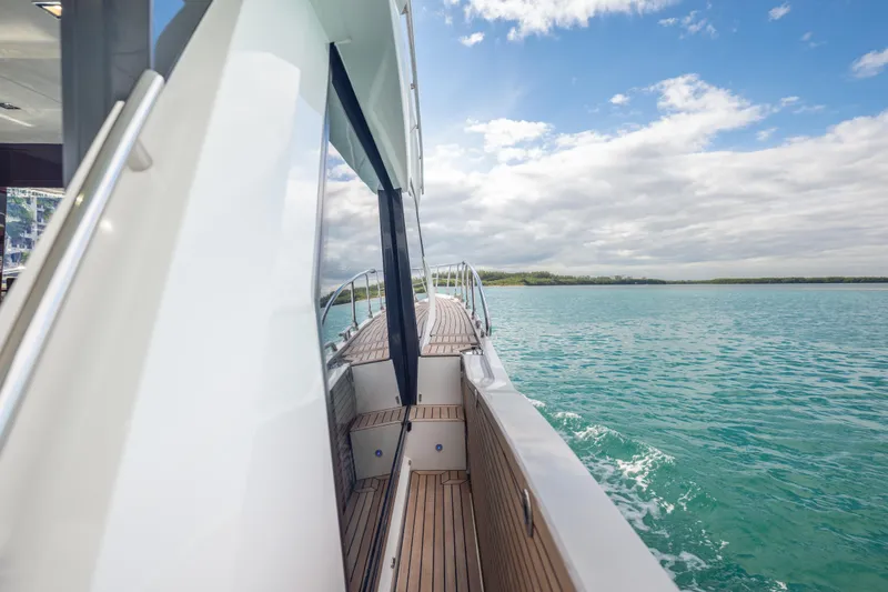 Slide: The Image of Galeon 500 Fly 2020 yacht cruising on turquoise waters under a partly cloudy sky. - 65