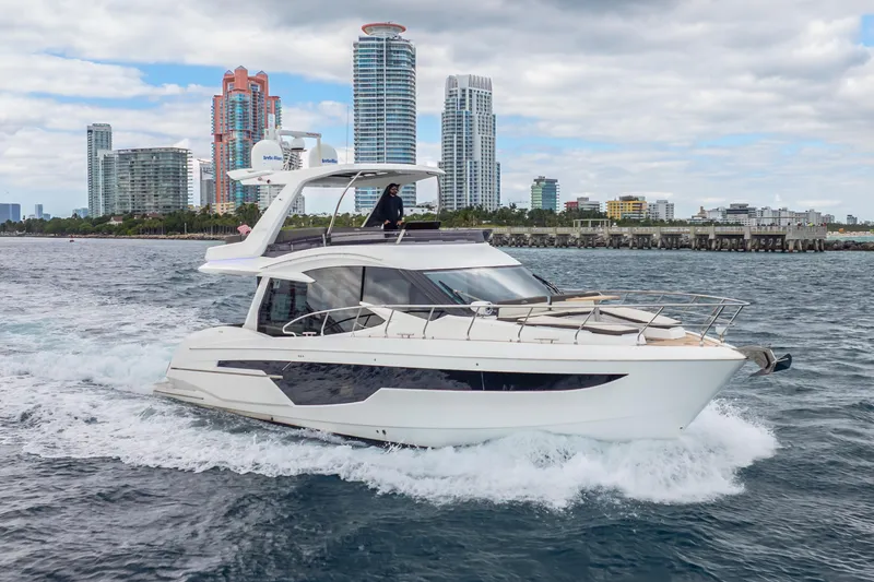 Slide: The Image of 2020 Galeon 500 Fly yacht cruising near city skyline, under cloudy sky. - 70