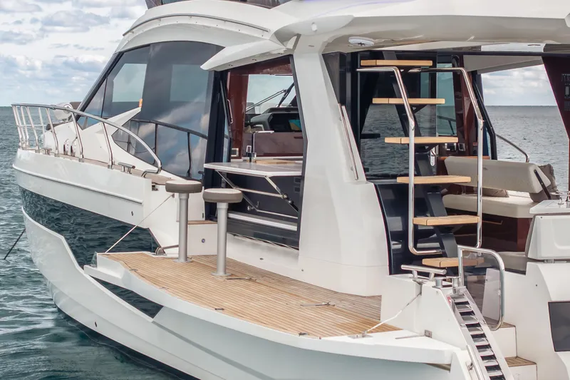 Slide: The Image of 2020 Galeon 500 Fly yacht with modern design, featuring outdoor seating and elegant staircase. - 9