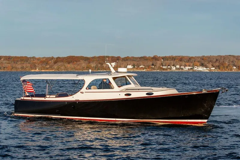 Slide: The Image of 2001 Hinckley Ya Picn boat interior with captain navigating on open water. - 11