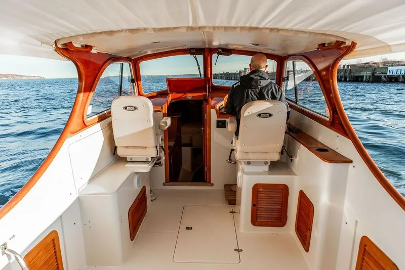 Slide: The Image of 2001 Hinckley Ya Picn boat interior with person steering on open water. - 12