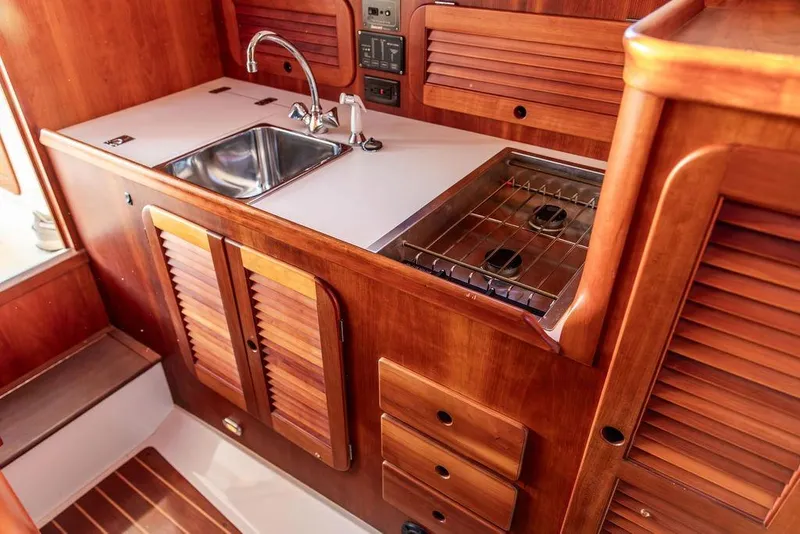 Slide: The Image of Hinckley Ya Picn 2001 yacht kitchen with stainless steel sink and wooden cabinetry. - 23