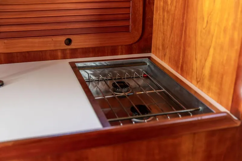 Slide: The Image of 2001 Hinckley Ya Picn yacht interior with wooden cabinetry and built-in stove. - 25