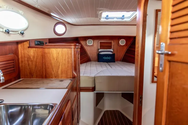 Slide: The Image of Interior of 2001 Hinckley Ya Picn boat with wooden cabinetry and cozy sleeping area. - 26